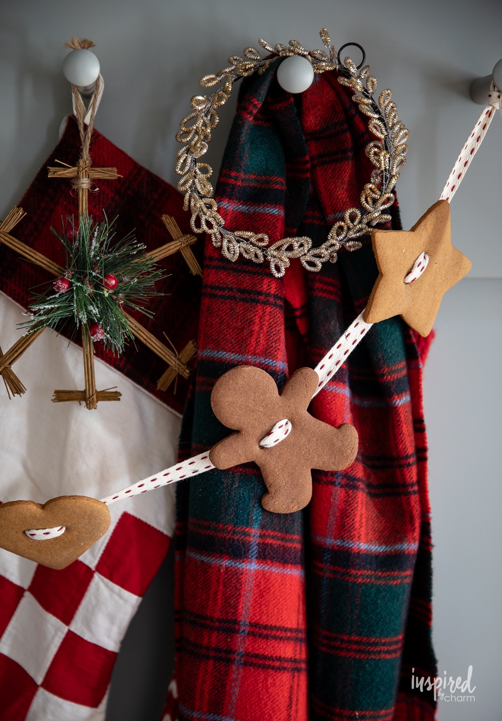 gingerbread garlad hung on pegs on vintage red plaid scarf.