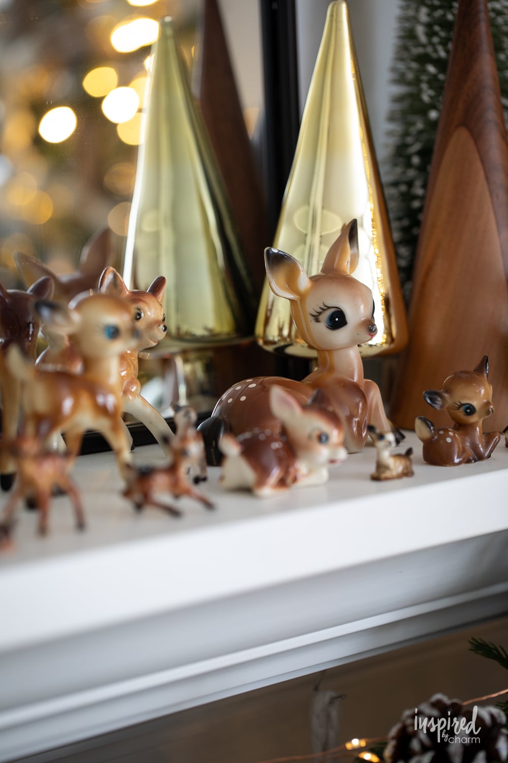 plastic Christmas deer fawns on a mantel decorated for Christmas.