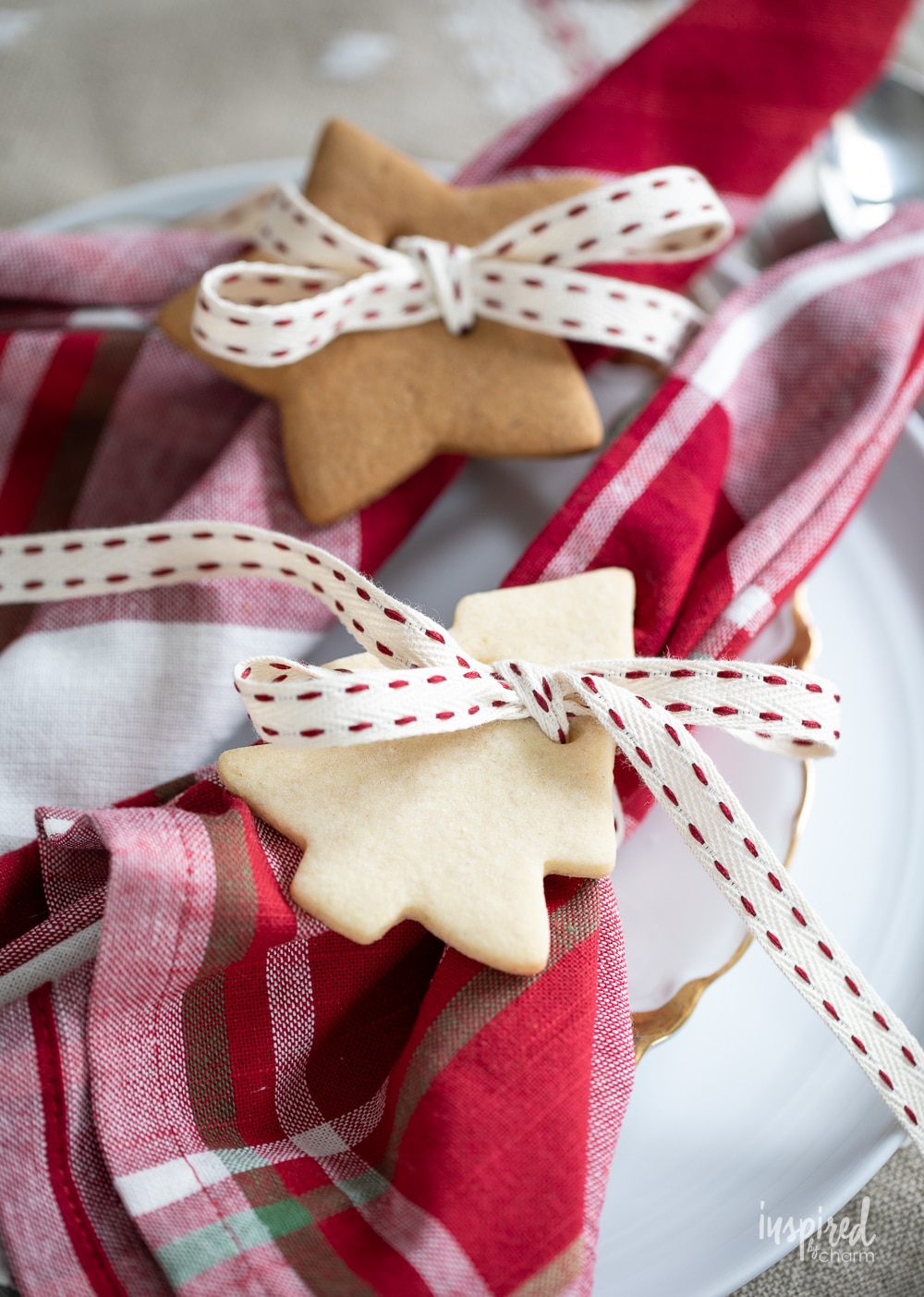 two cookies and ribbon tied around a napkin for a napkin ring.