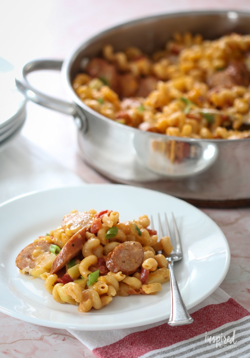 chicken apple sausage pasta in large skillet and served on a white plate.