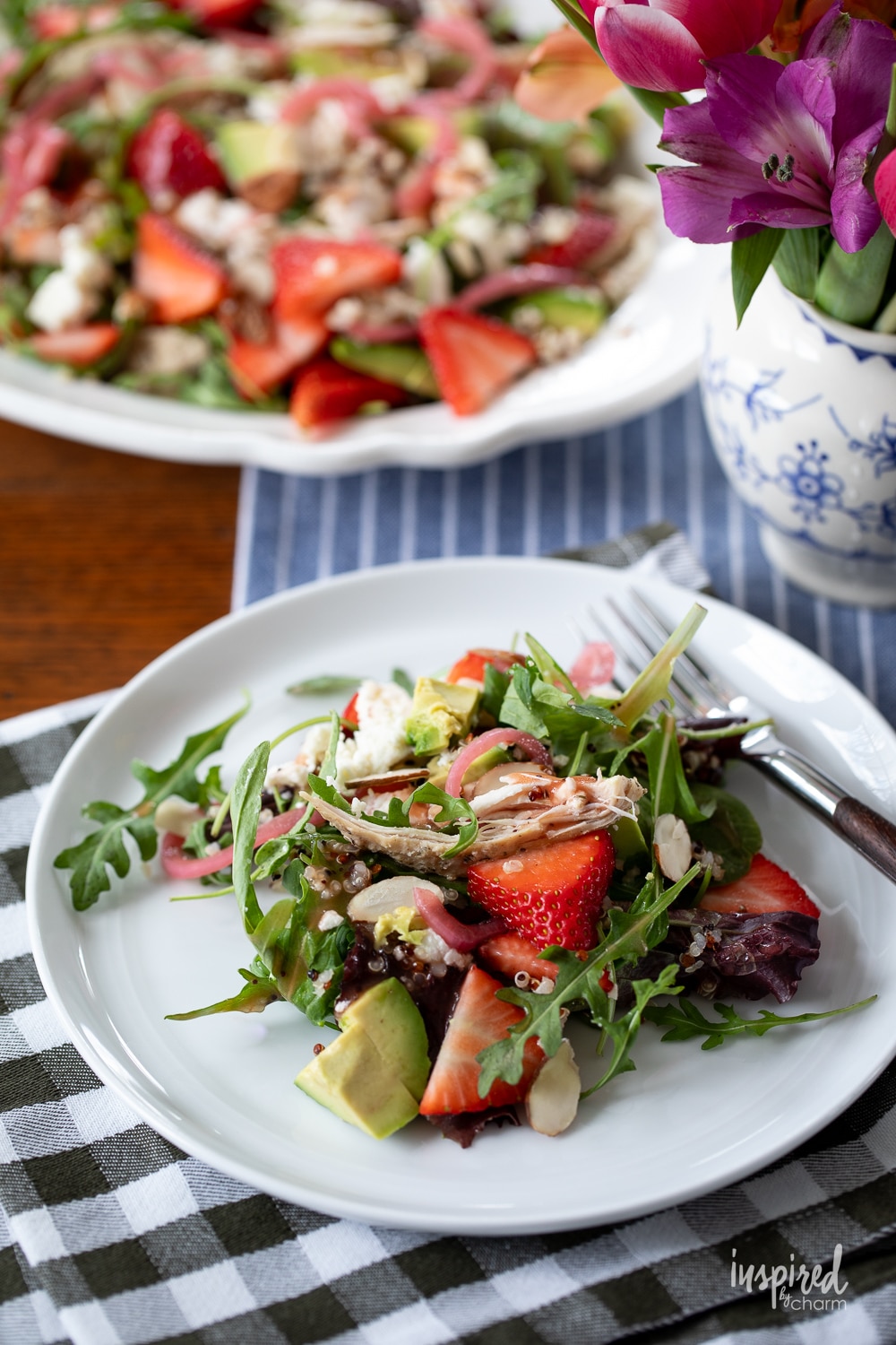 Chicken Quinoa Strawberry Salad on a plate on a table with a fork. 
