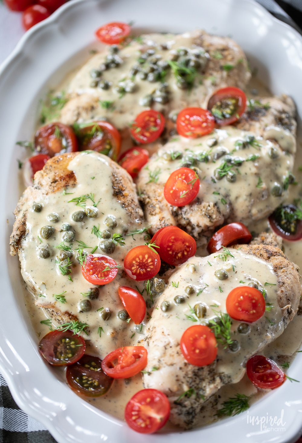dinner spread with a platter of chicken with caper cream sauce.