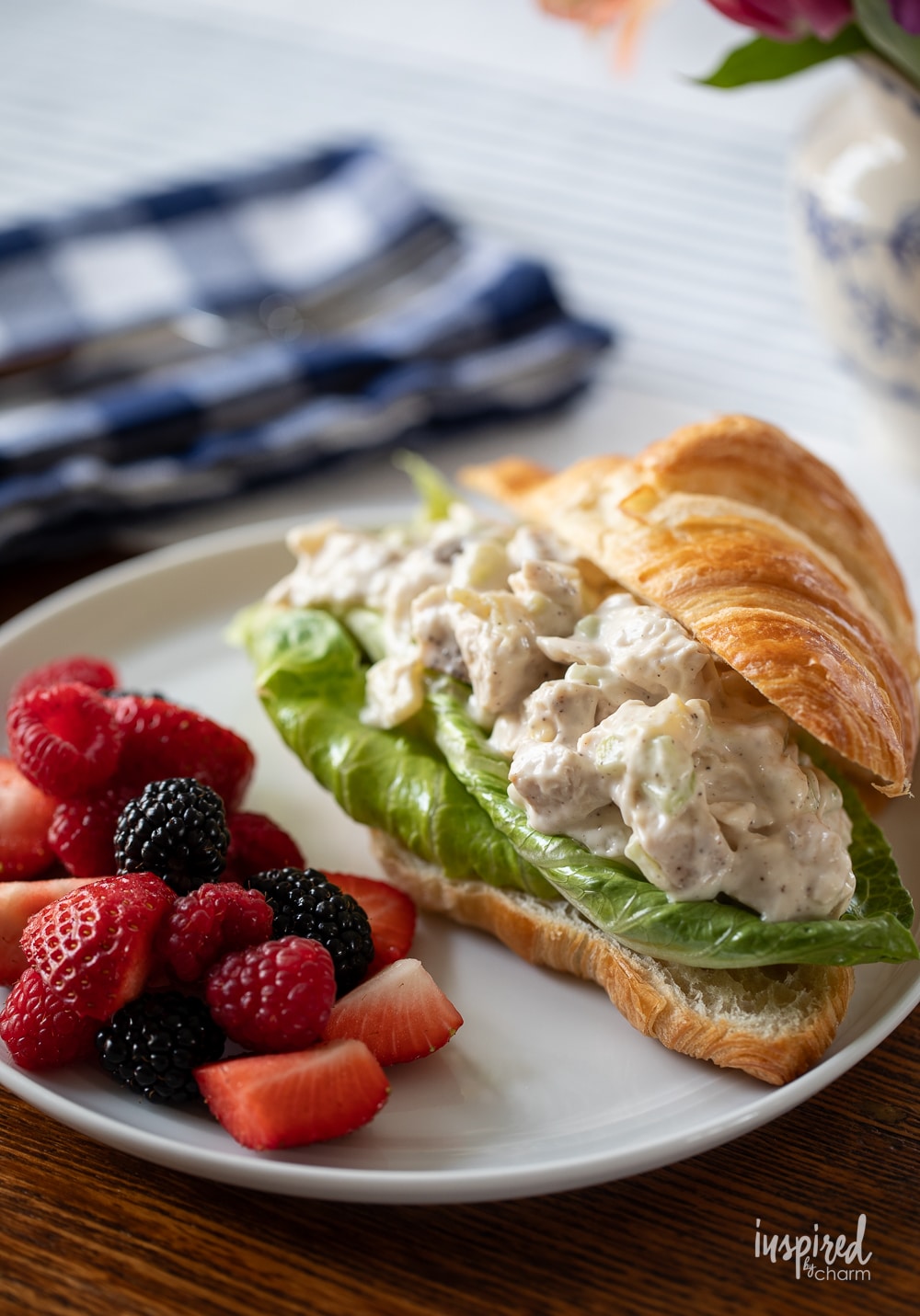 chicken salad sandwich on a plate with berries. 