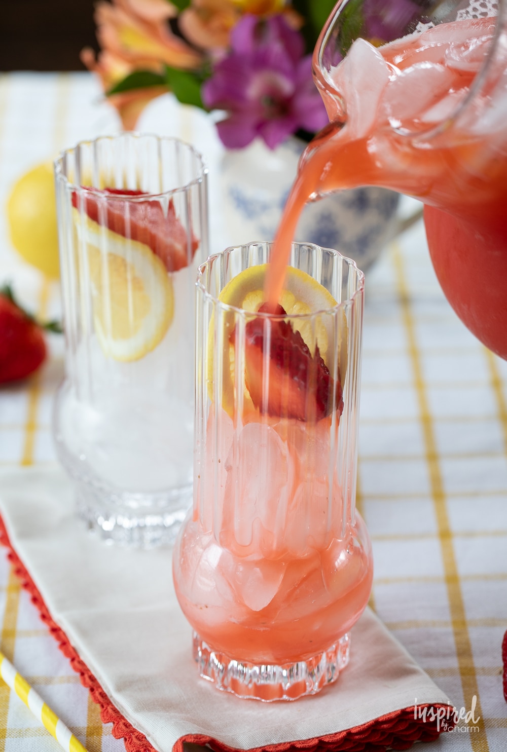pouring Strawberry Lemonade Vodka Cocktail into a glass with ice.