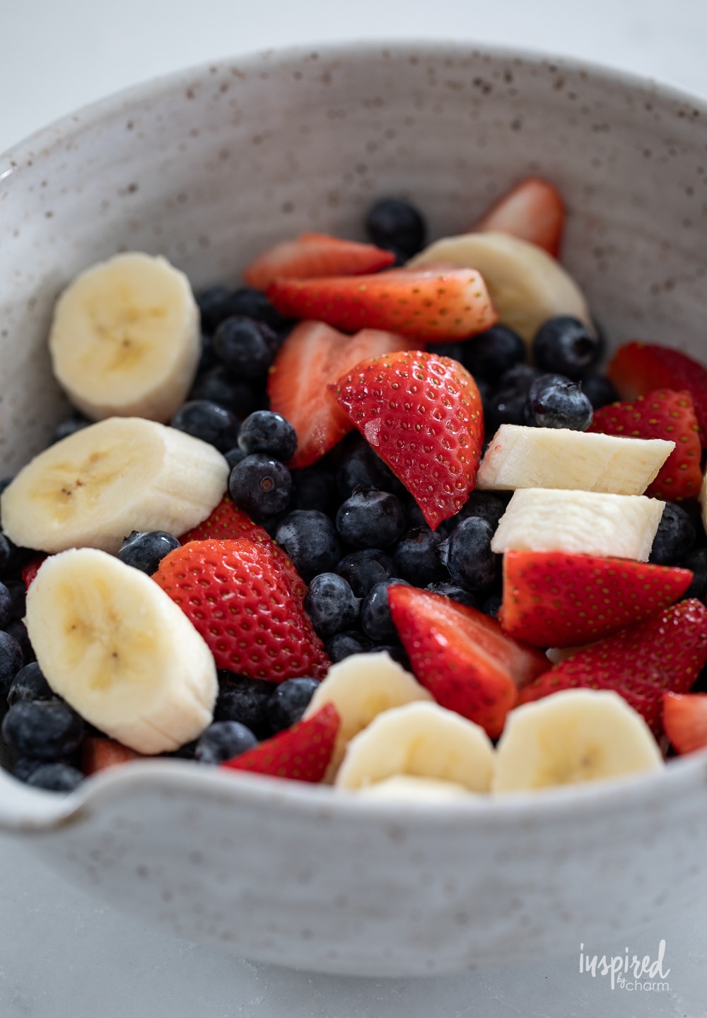bowl of fruit with berries and bananas.
