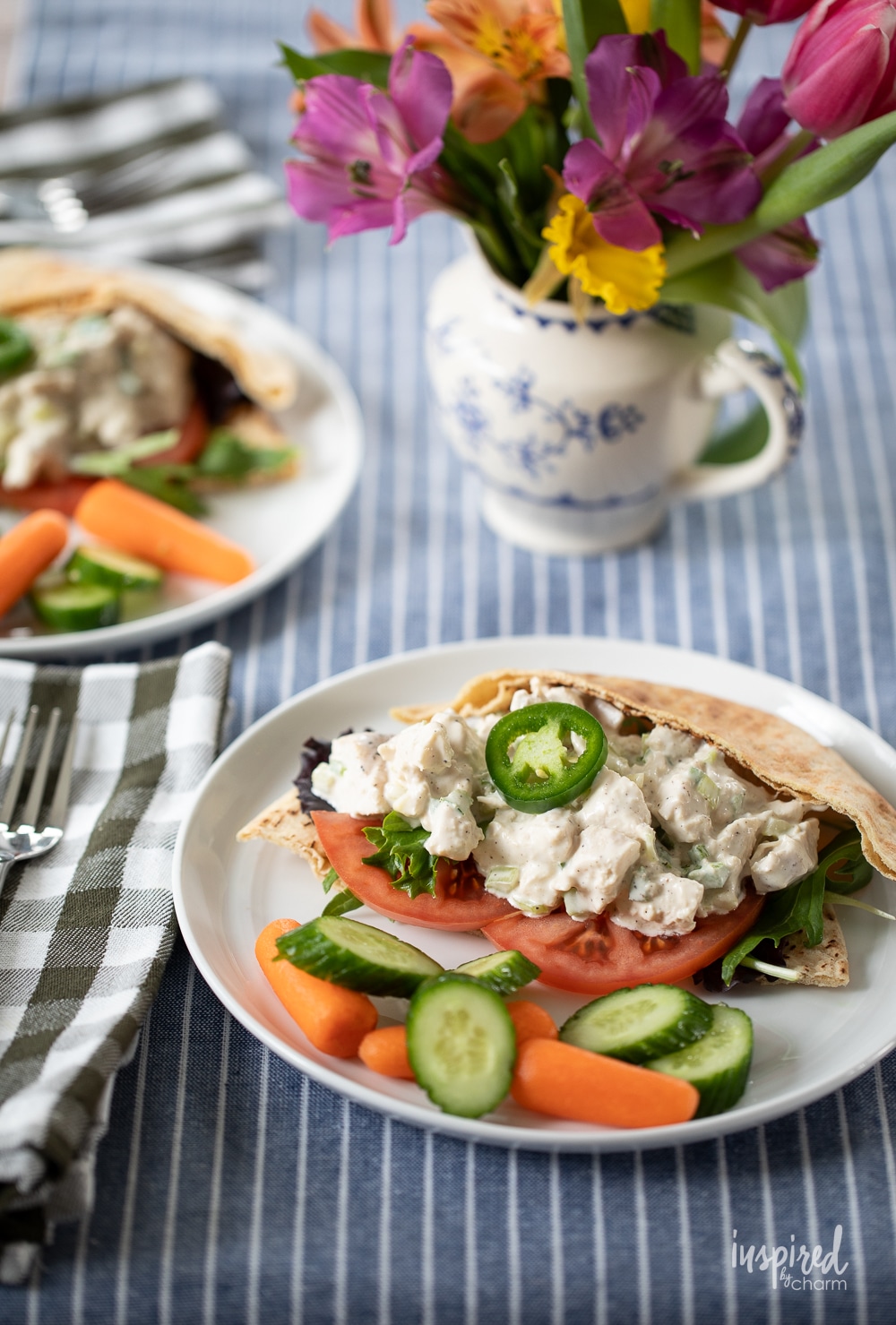 two plated with Jalapeño Honey Chicken Salad served in pitas and with fresh vegetables.