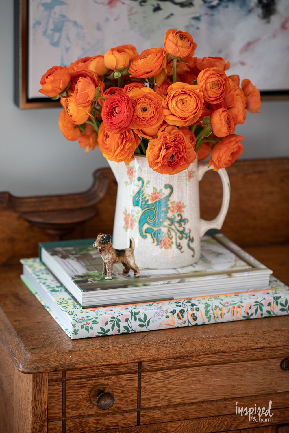 orange ranunculus flowers in a transferware vase.