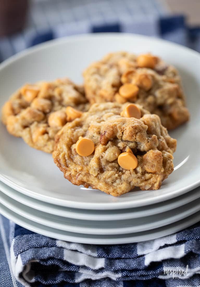 three butterscotch chip oatmeal cookies on a stack of white plates.