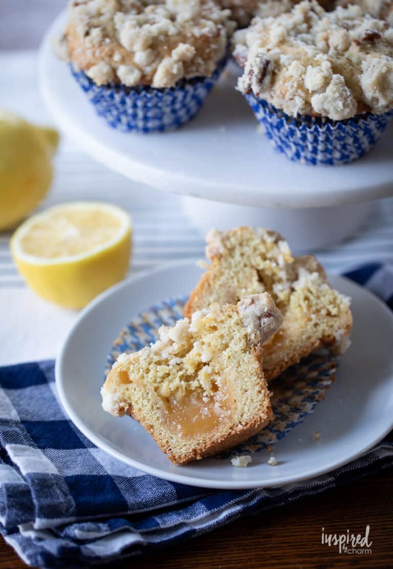 lemon curd muffin cut in half on a white plate.