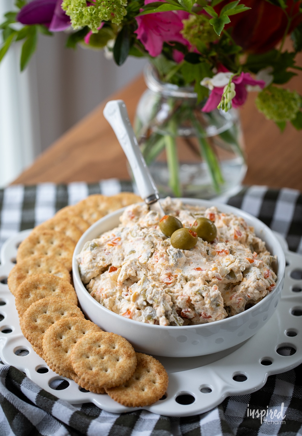 the ultimate olive dip served in a bowl with Ritz crackers.