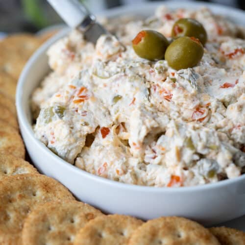 the best olive dip in a bowl garnished with olives.