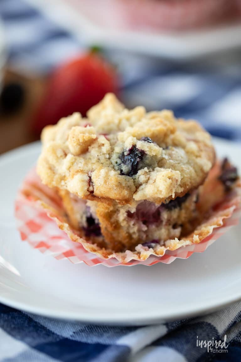 Triple Berry Muffin with paper liner removed on a white plate.