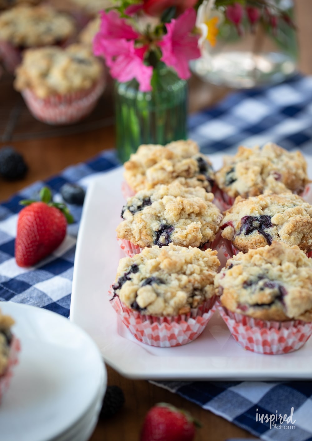 six triple berry muffins on a plate.