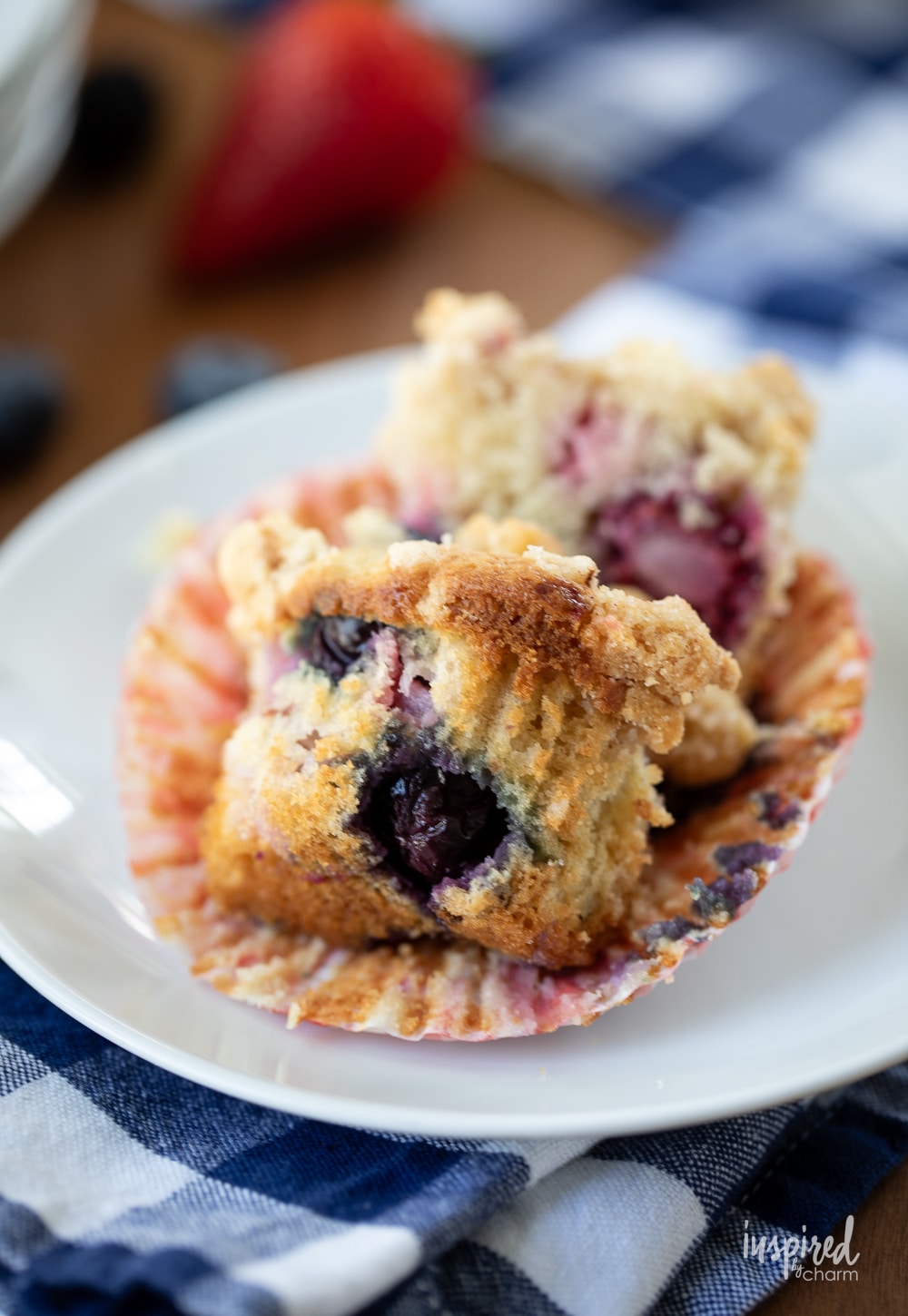 triple berry muffin cut in half on a plate.