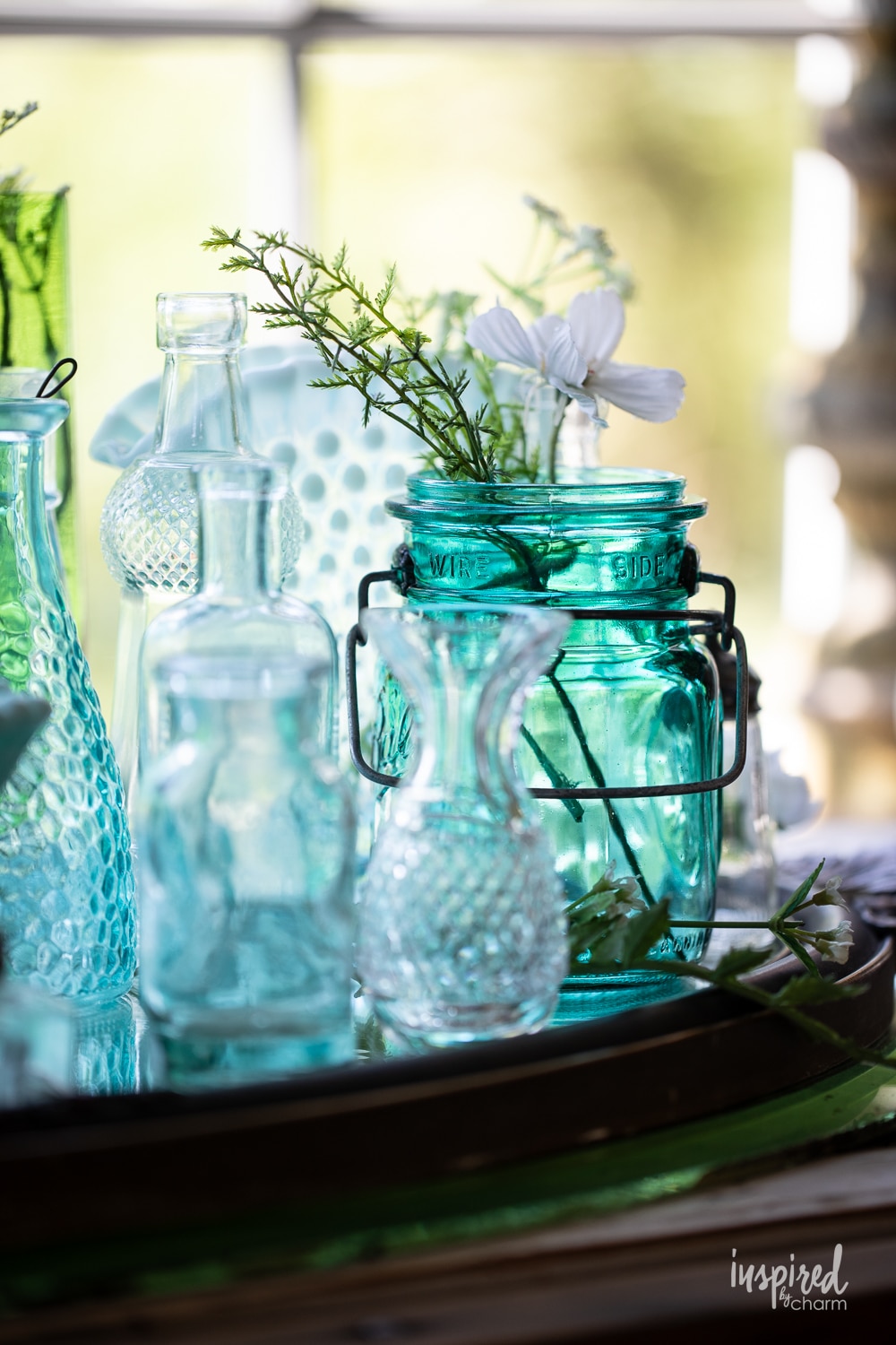 display of vintage glass jars and containers in front of a window. 