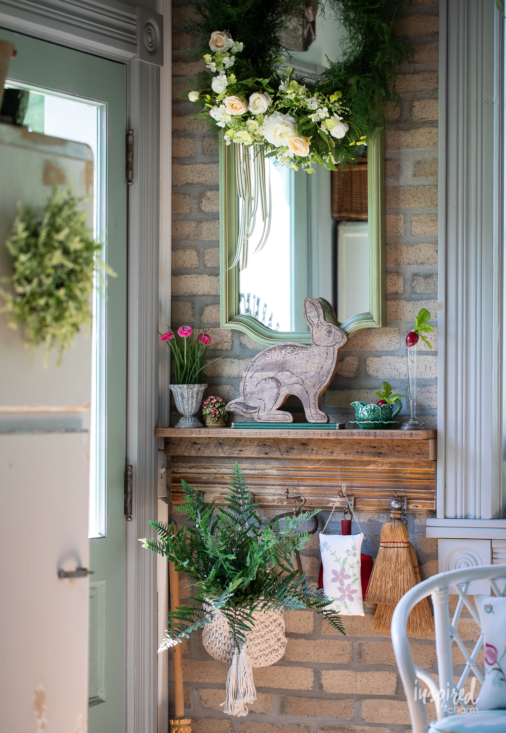 wood shelf with garden decor and mirror hanging above.