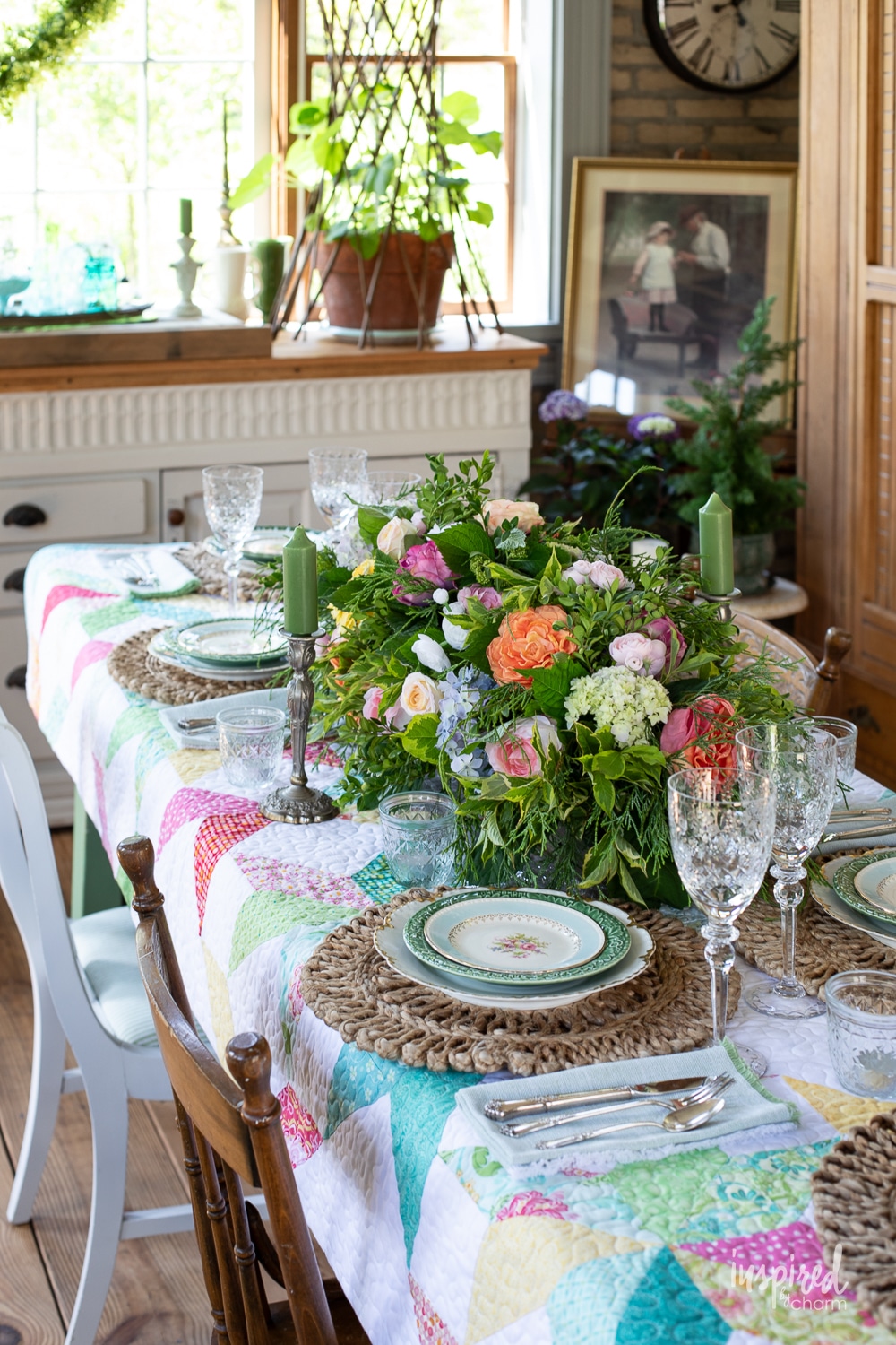 garden table set with vintage dinnerware and a quilt. 