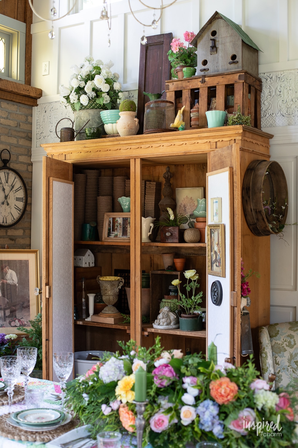 large wood cabinet with doors opened filled with vintage and garden treasures. 