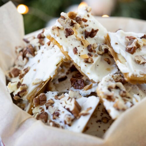 Salted White Chocolate Toffee with pecans on top in a holiday tin.