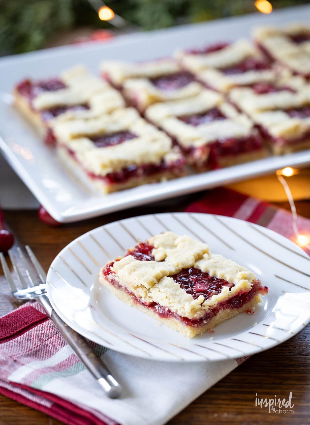 festive table set with apple cranberry bars on a platter and plate.