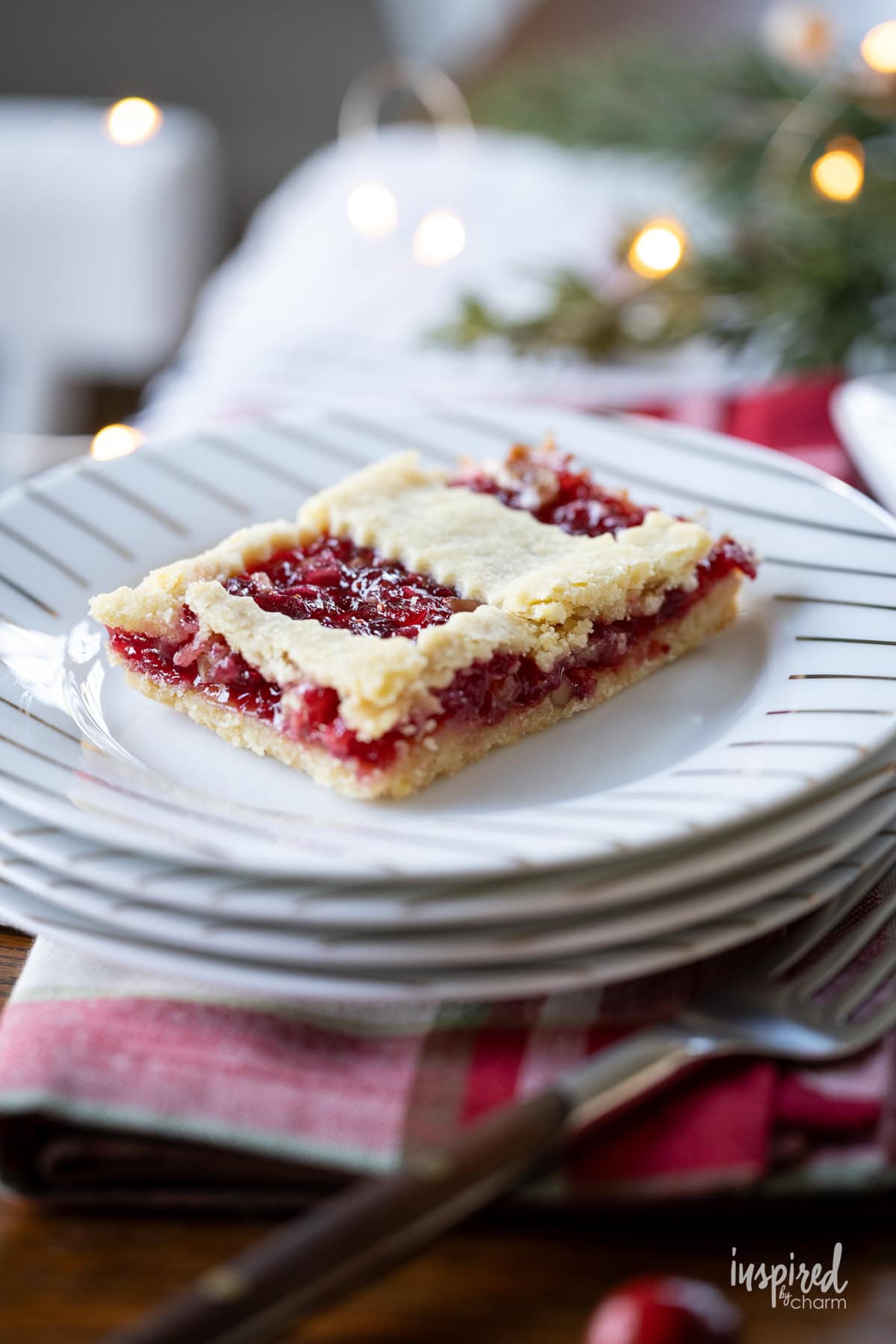 piece of apple cranberry bars on a stack of white plate.