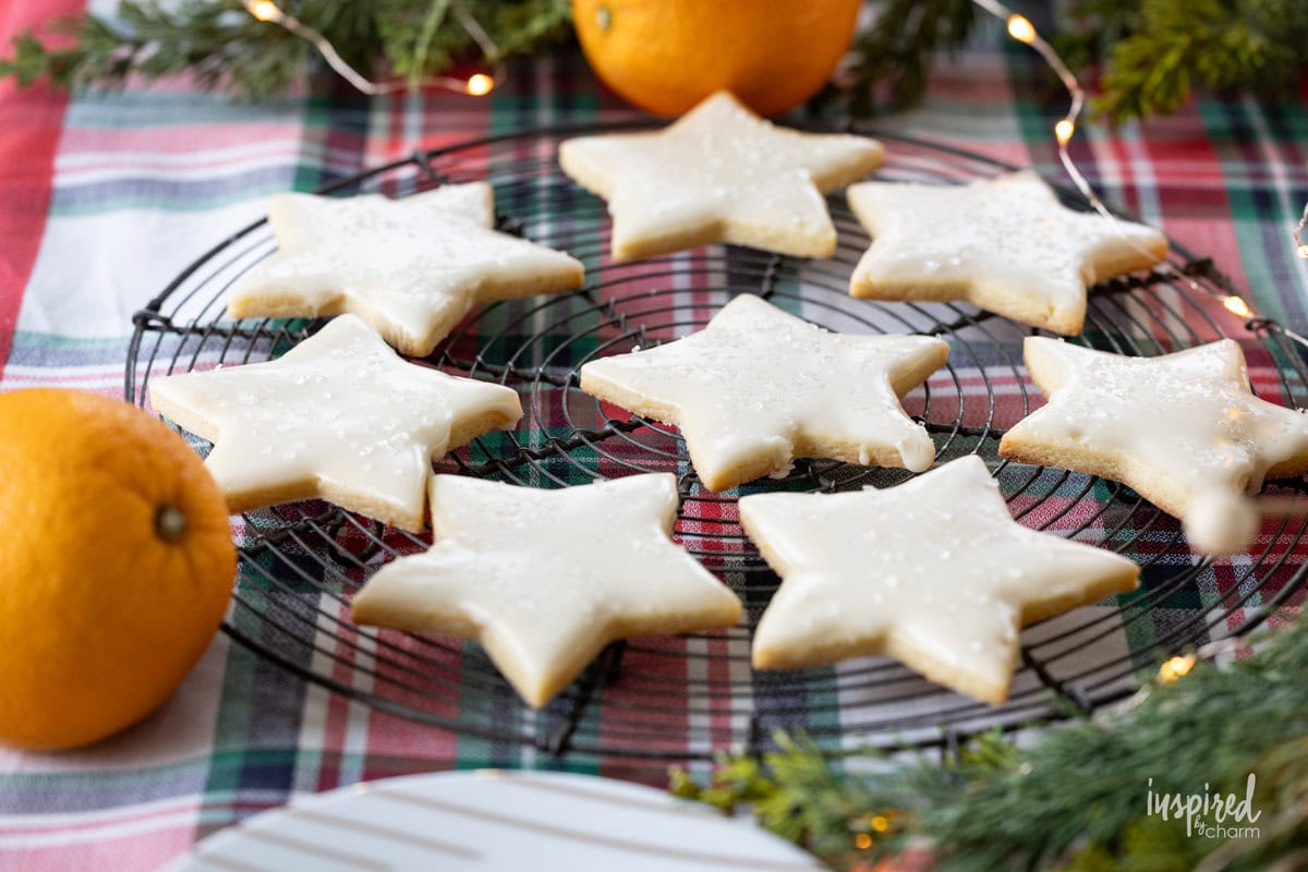 star shaped orange sugar cookie on a table with festive decor.