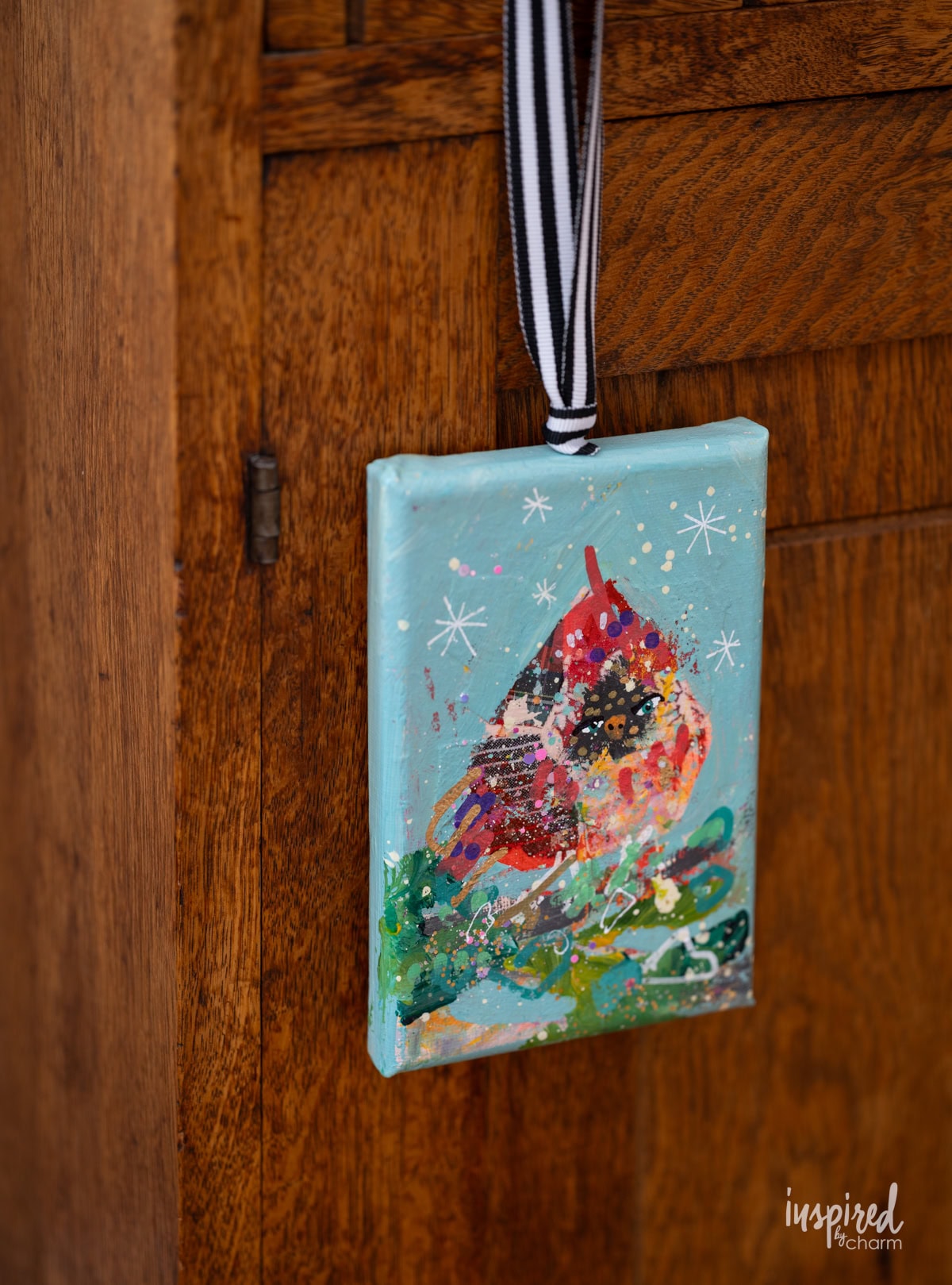 cardinal painting hung on a knob. 
