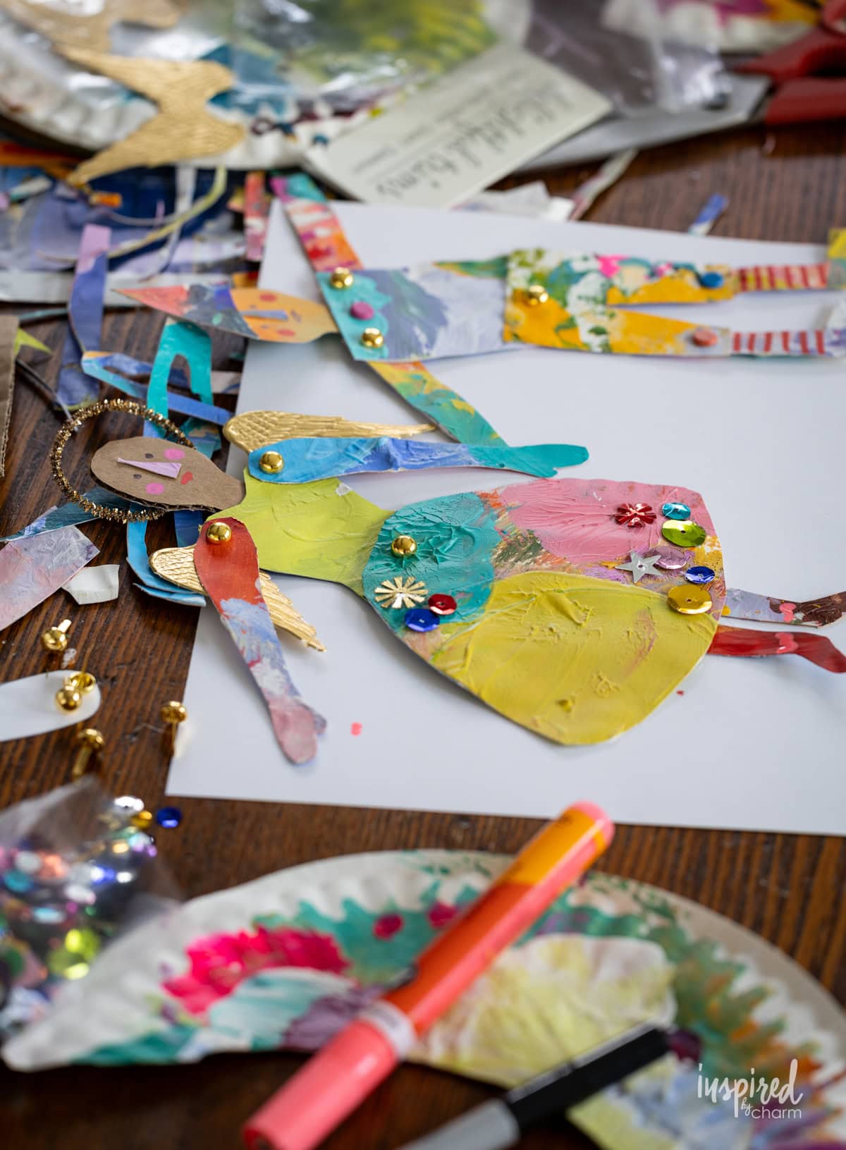 Painted Paper Plate Articulated Christmas Figures on a table.