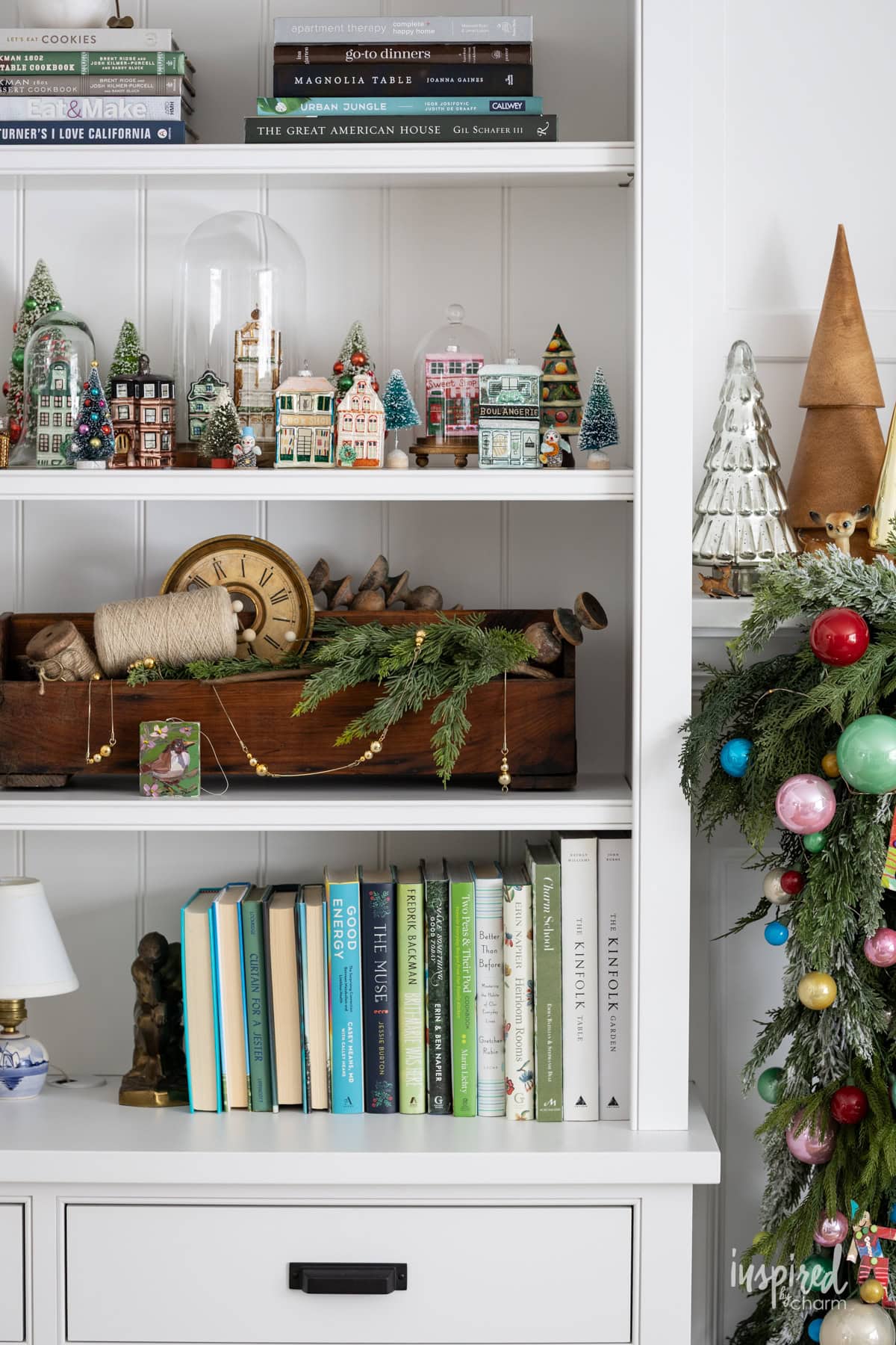 glass house christmas ornament collection on a shelf. 
