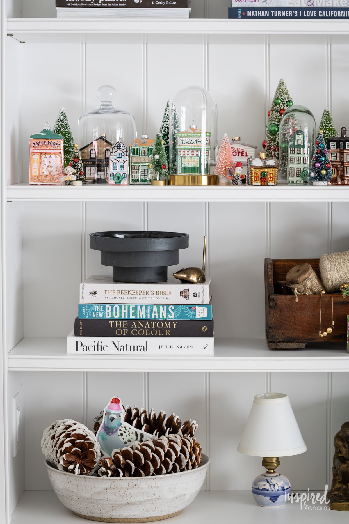 shelf with glass christmas house ornament collection. 