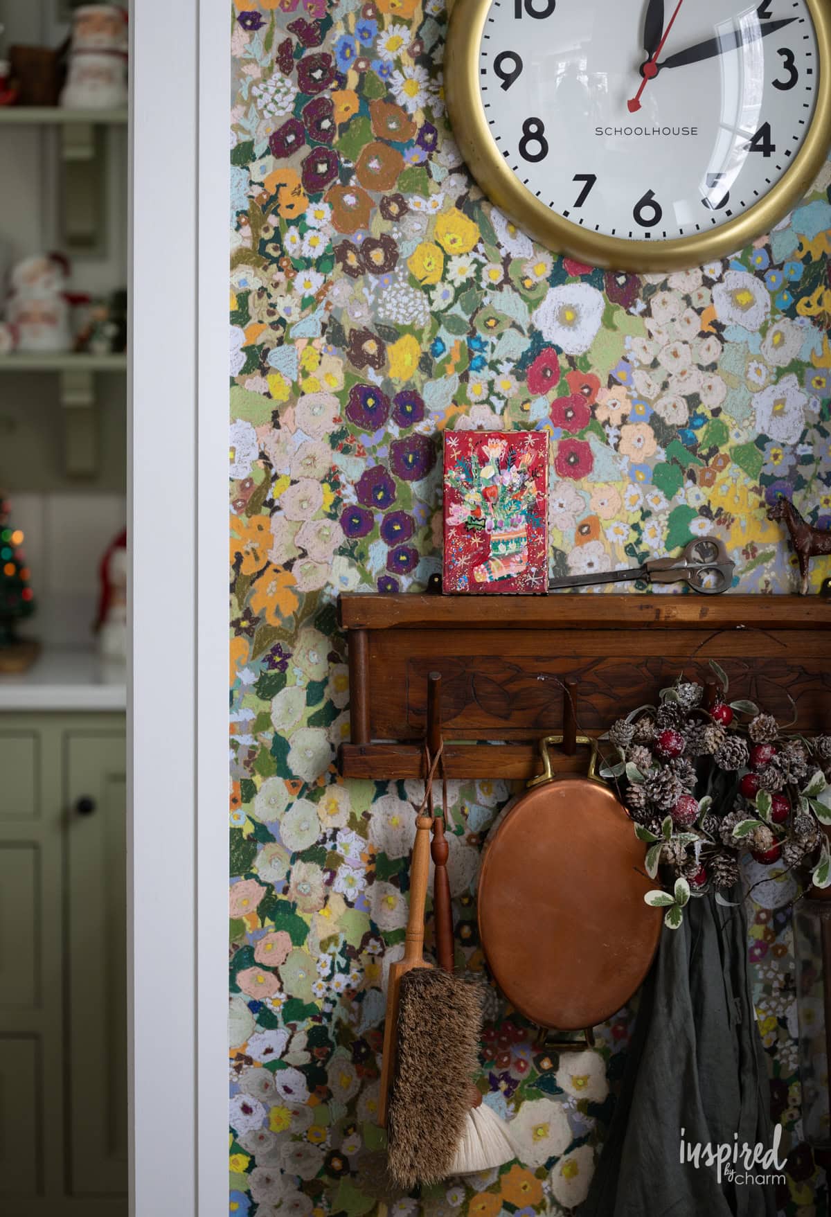 artwork on a shelf with a wallpapered wall.