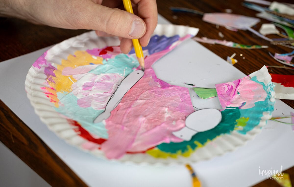 hand tracing shape onto painted paper.