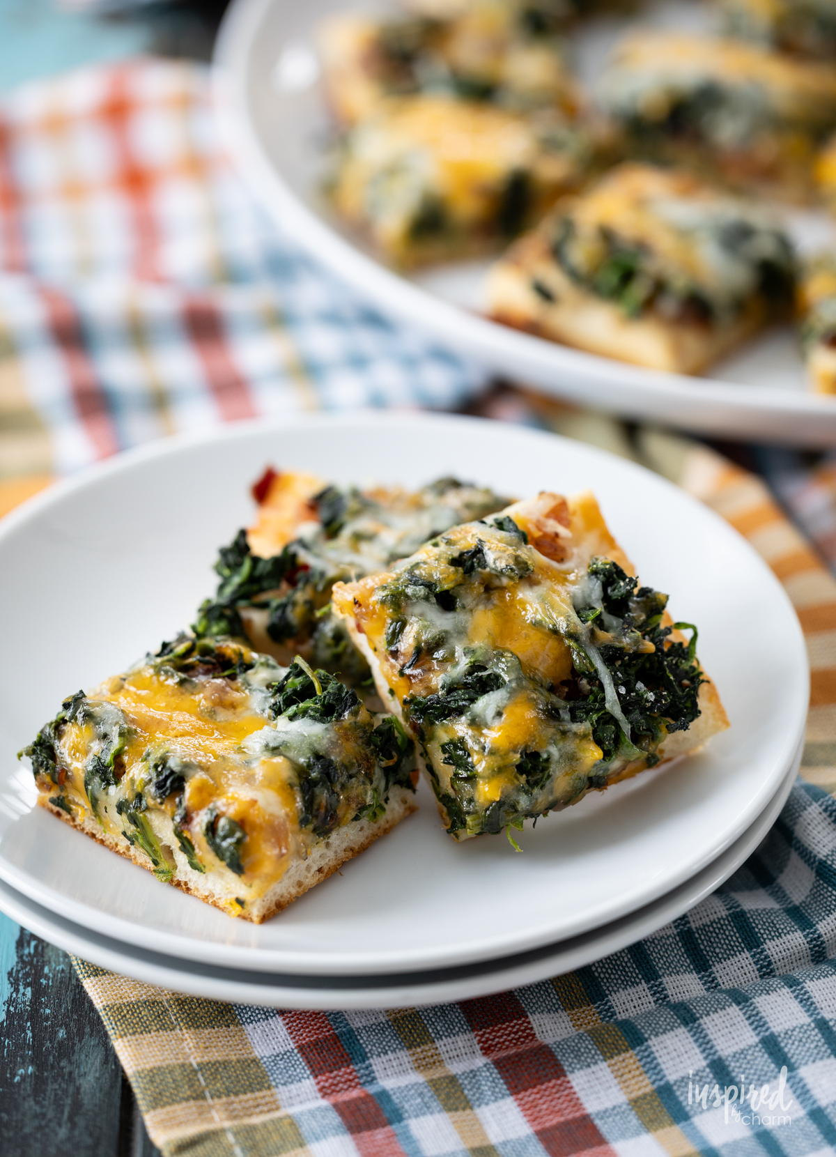 stack of three Cheesy Spinach Bacon Appetizer Bars on a plate.
