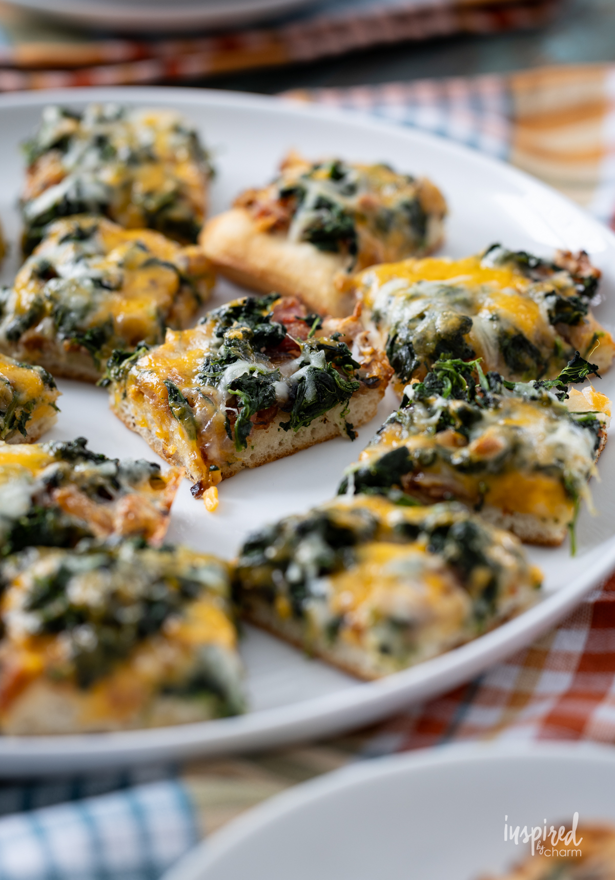 array of Cheesy Spinach Bacon Appetizer Bars on a round plate.