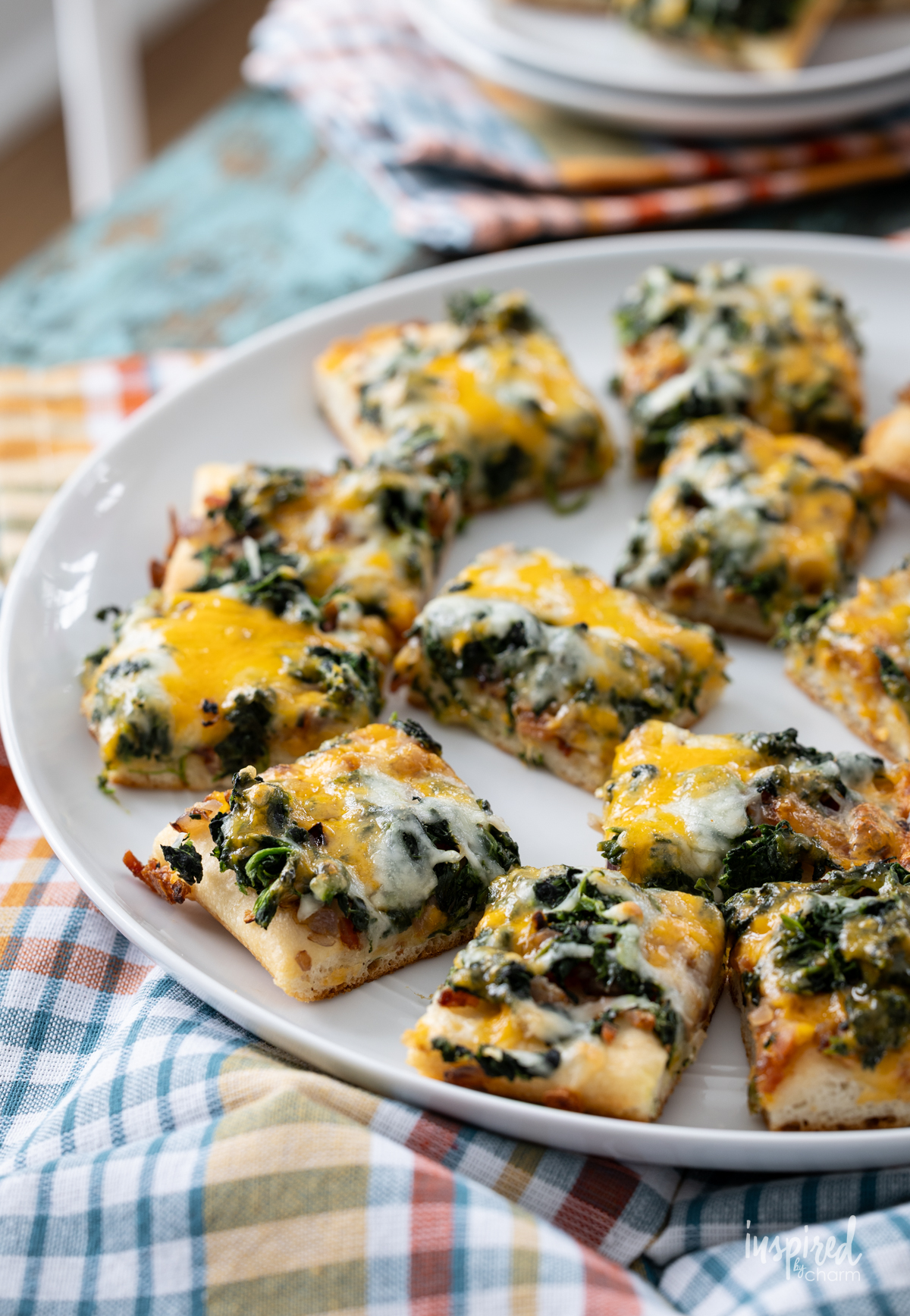 round white platter filled with Cheesy Spinach Bacon Appetizer Bars.