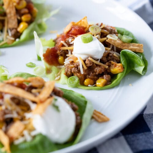 taco lettuce cups with toppings on a plate.