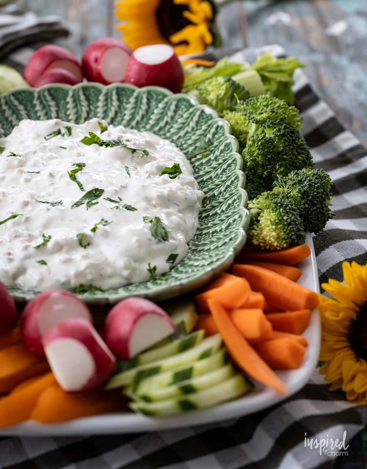 vegetables surrounding a bowl filled with creamy garden vegetable dip.