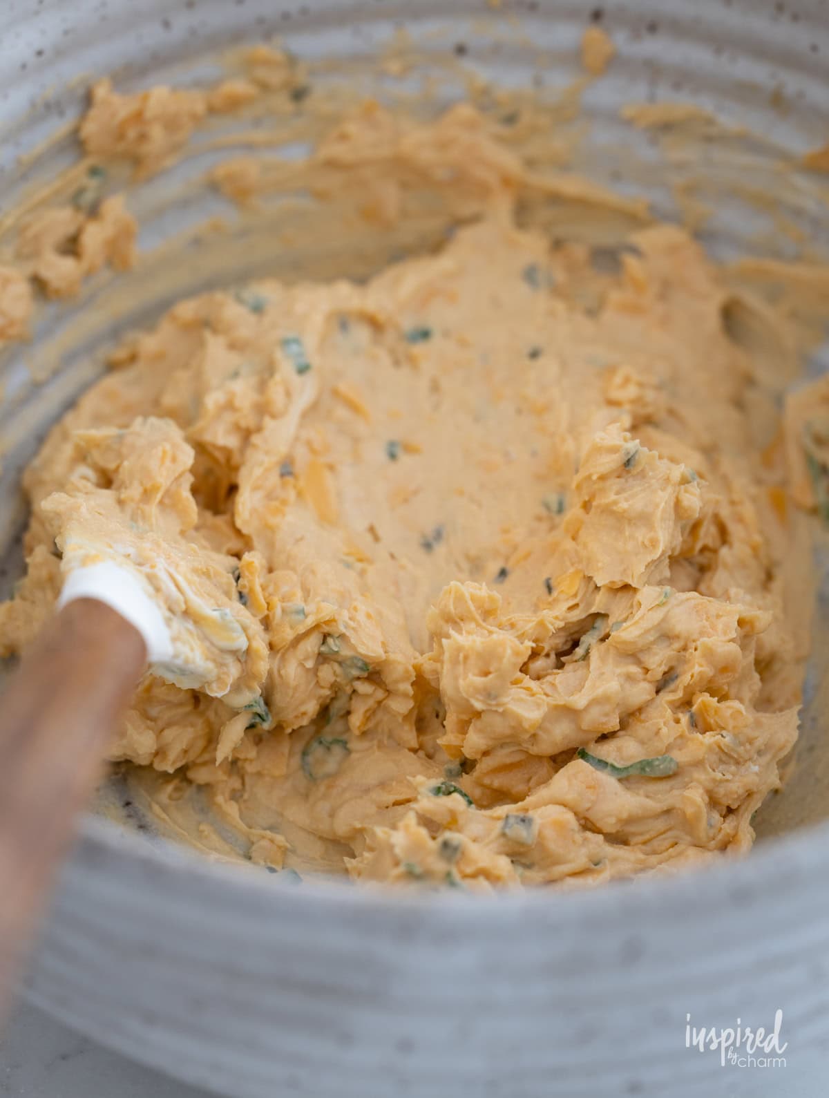 bowl filled with Pub-Style Cheddar Cheese Dip and a spatula.
