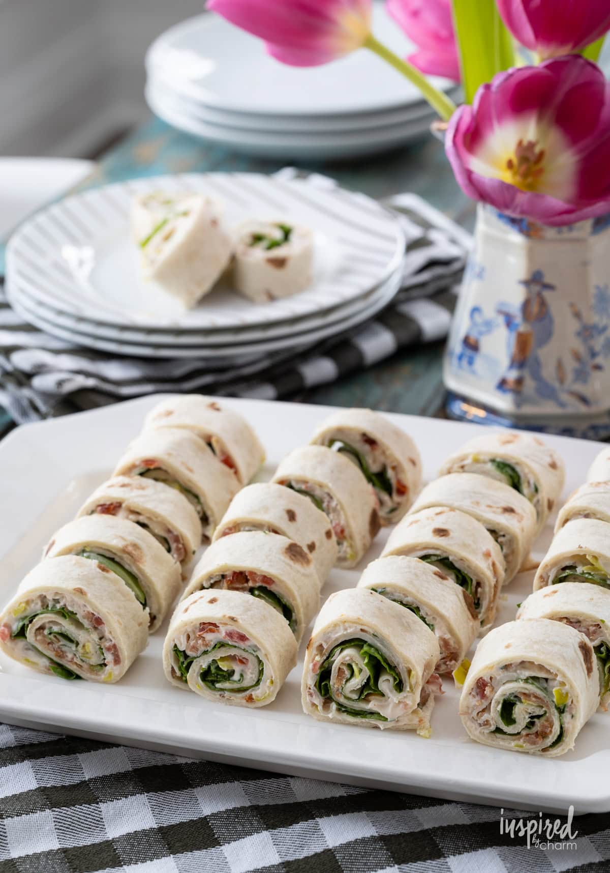 table with platter filled with Turkey Club Sandwich Roll-Ups.