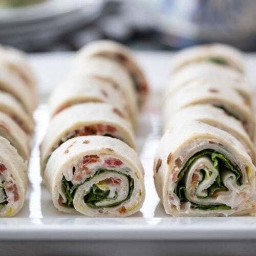 rows of Turkey Club Sandwich Roll-Ups on plate.