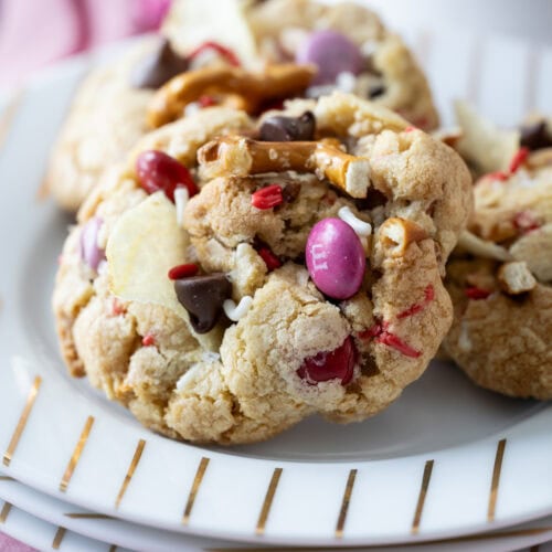 three Kitchen Sink Cookies for Valentine’s Day on a stack of small plates.