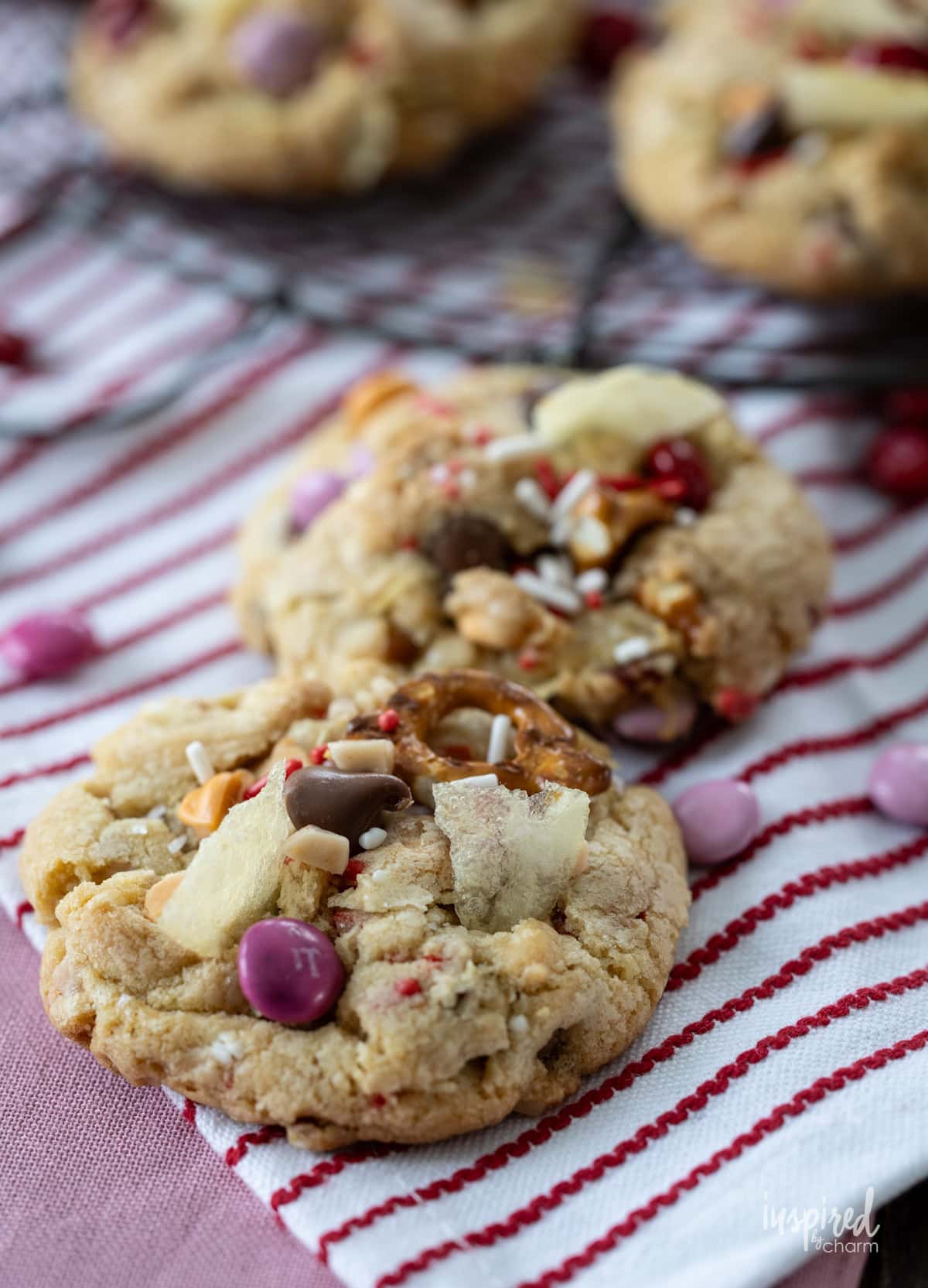 two Kitchen Sink Cookies for Valentine’s Day on a striped napkin.