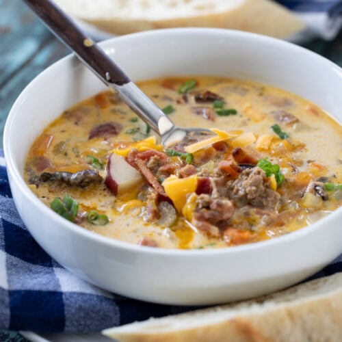 bowl of cheeseburger soup with a spoon in it.