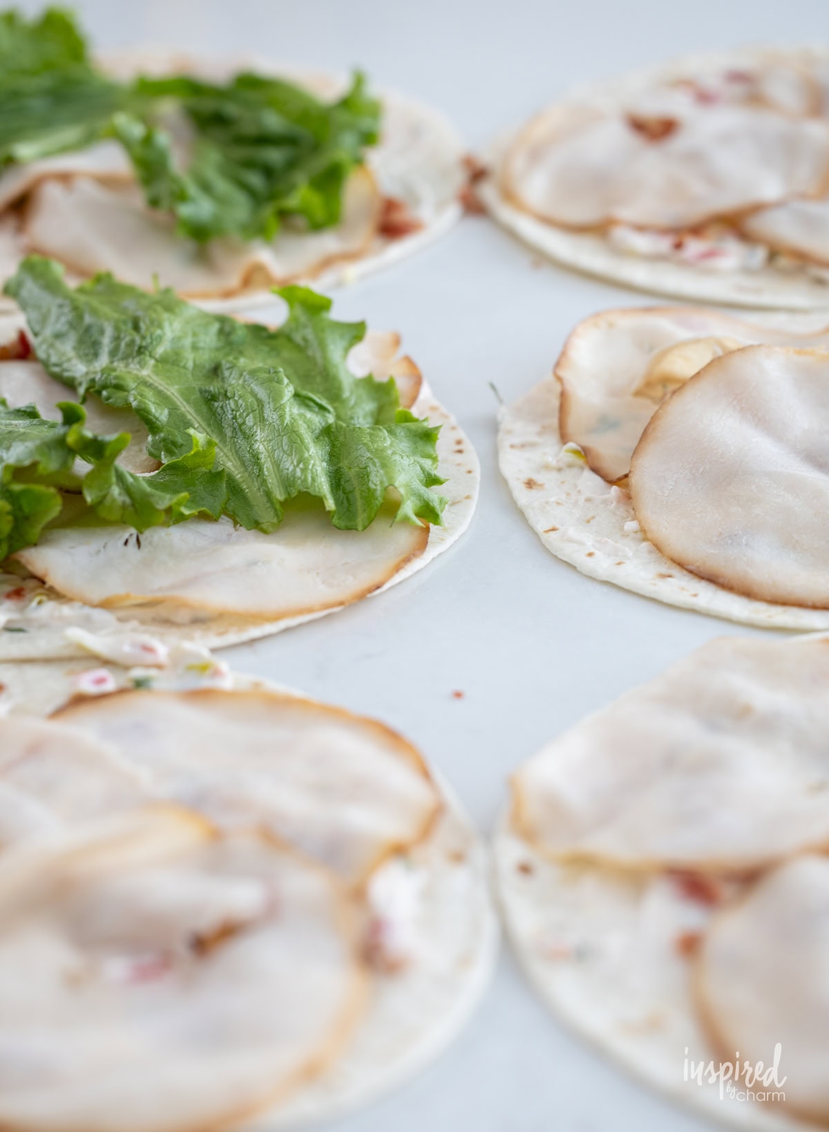 tortillas with cheese spread turkey and lettuce.