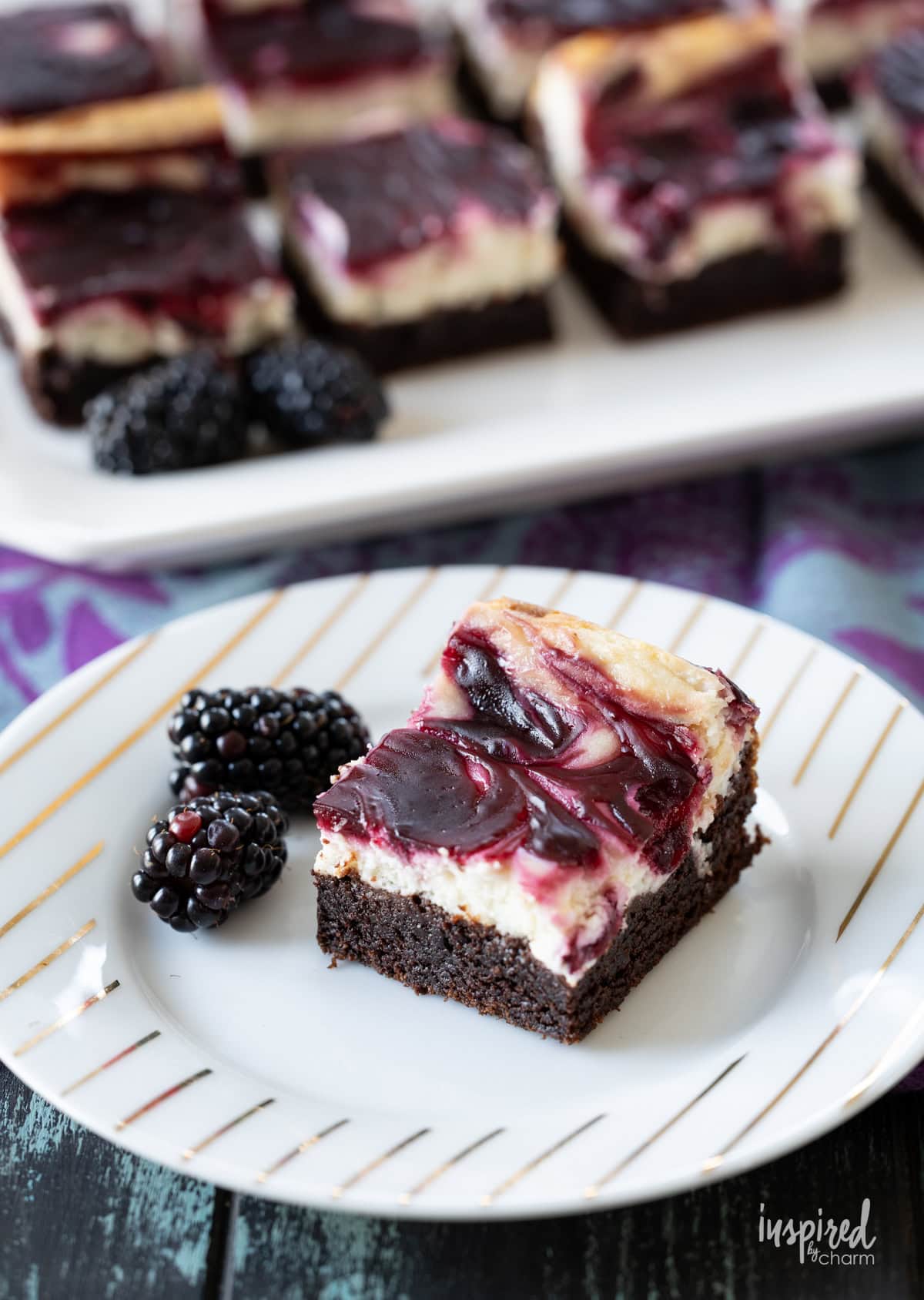 single piece of blackberry cheesecake brownie on a plate.