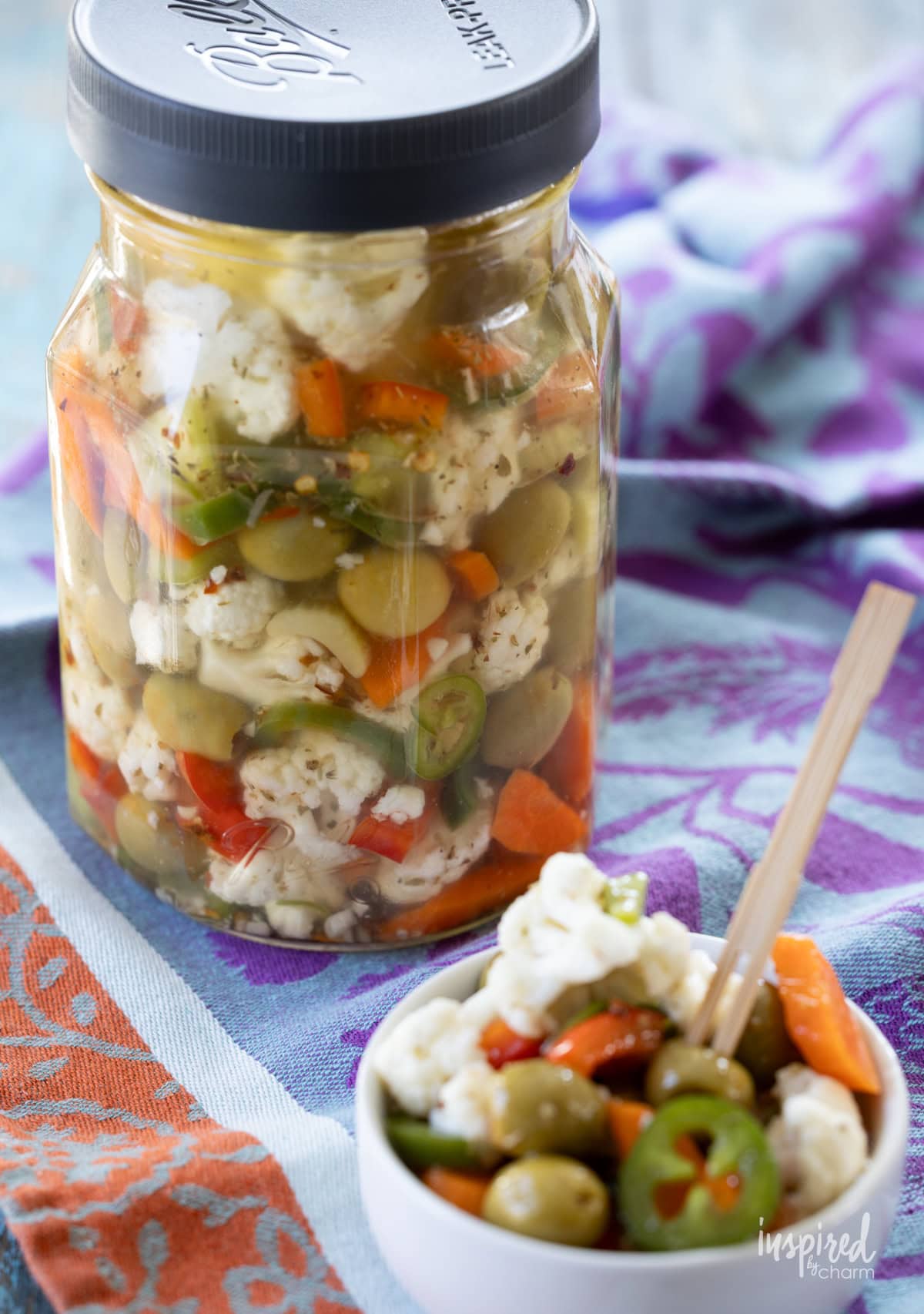 jar filled with homemade  Giardiniera and some served in a dish.