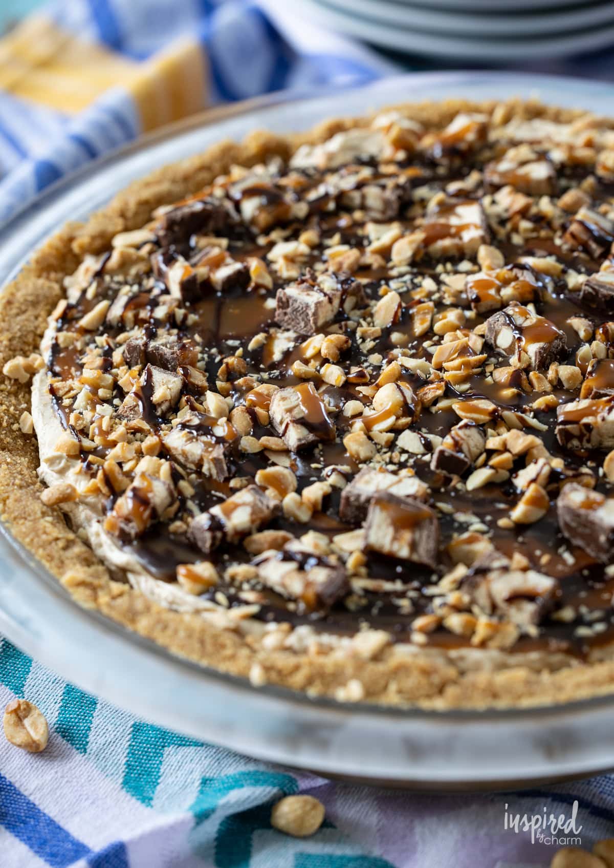 Peanut Butter Snickers Pie in a pie plate on a napkin.