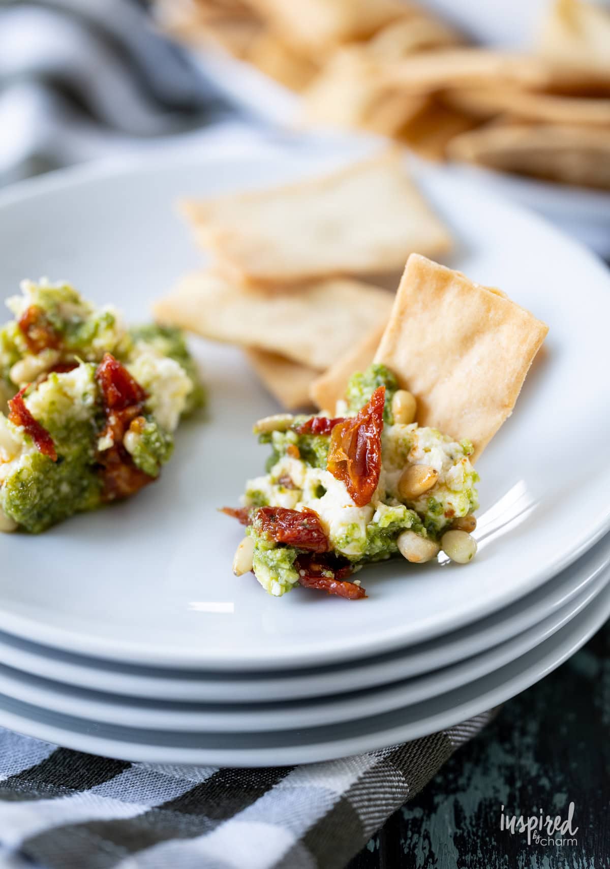 small plate with Pesto and Feta Layer Dip and served with chips.