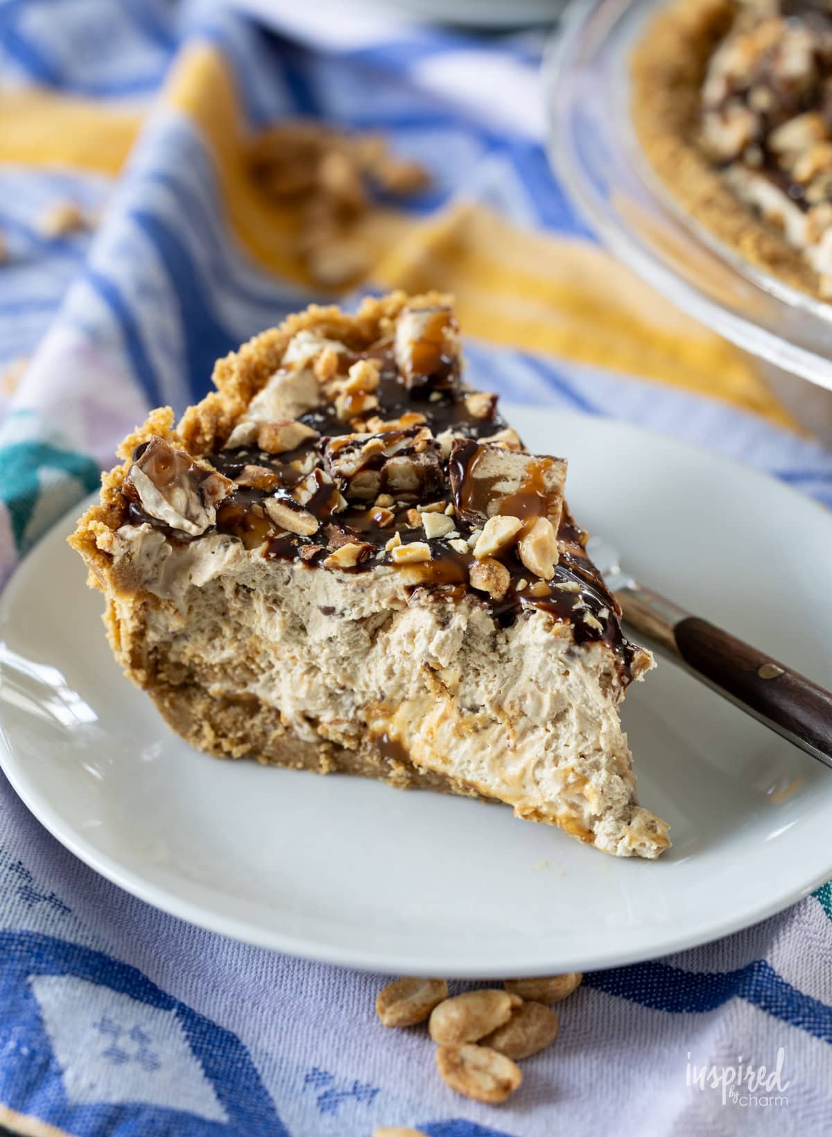 slice of peanut butter pie served on a plate with a fork.