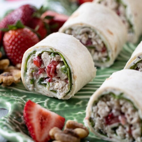 Strawberry Chicken Salad Sandwich Roll-Ups on a green platter.